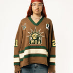 Female Model wearing the WOA Knitted Hockey Jersey with Embroidered WA logo, Captains patch and W.O.A liberty graphic standing against a white background.