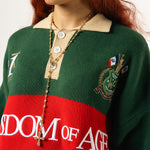 Close up of a female Model wearing a green and red, knitted rugby sweater with 'Wisdom of Age' text on a white background.