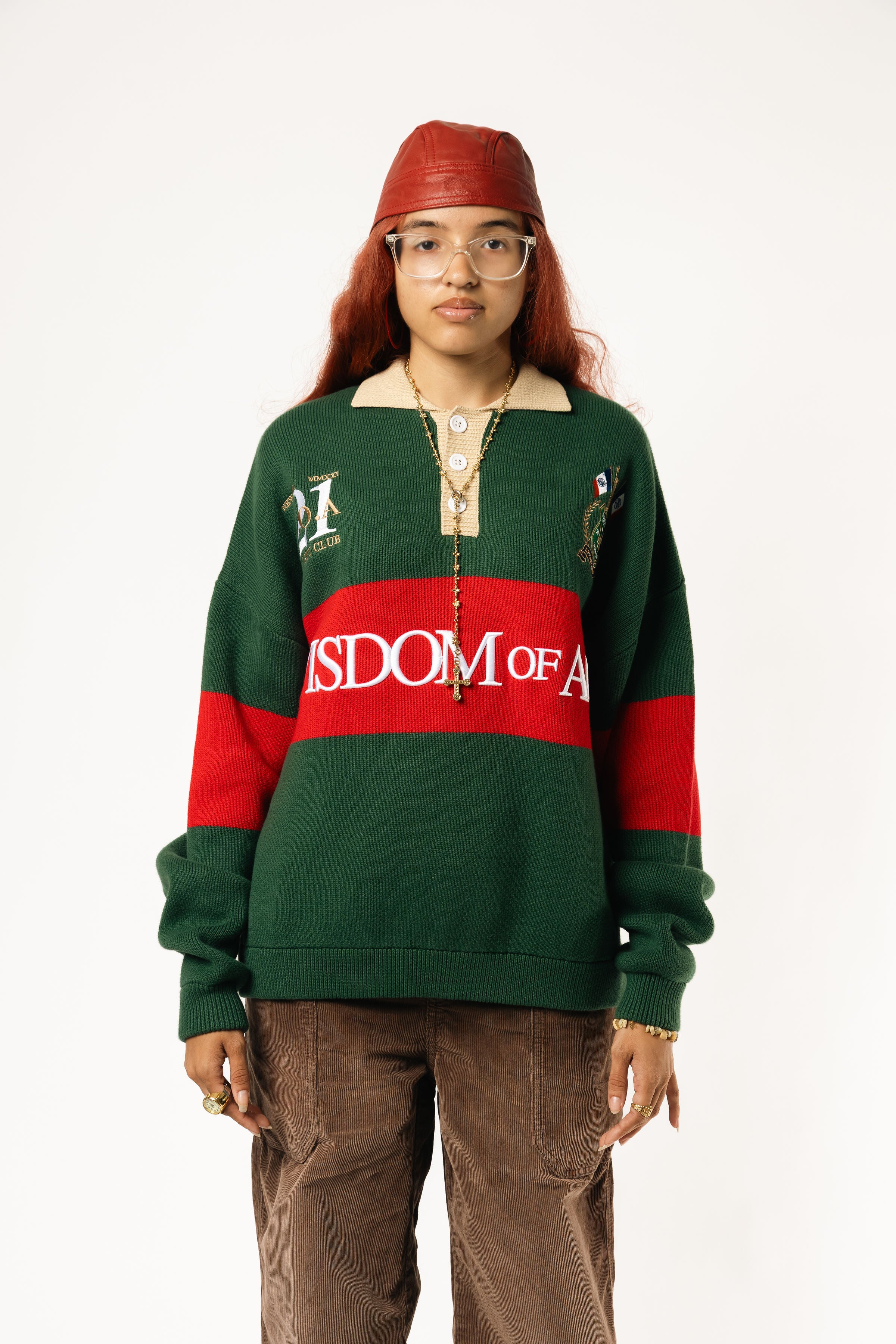 Female Model wearing a green and red, knitted rugby sweater with 'Wisdom of Age' text on a white background