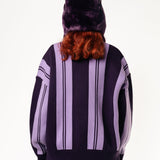 Rear View Of a female Model wearing WOA Knitted purple cardigan on a white background.