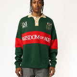 Male Model wearing a green and red, knitted rugby sweater with 'Wisdom of Age' text on a white background