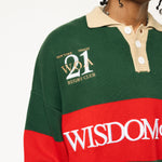 Close up of Male Model wearing a green and red, knitted rugby sweater with 'Wisdom of Age' text on a white background.
