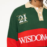 Close up of Male Model wearing a green and red, knitted rugby sweater with 'Wisdom of Age' text on a white background.