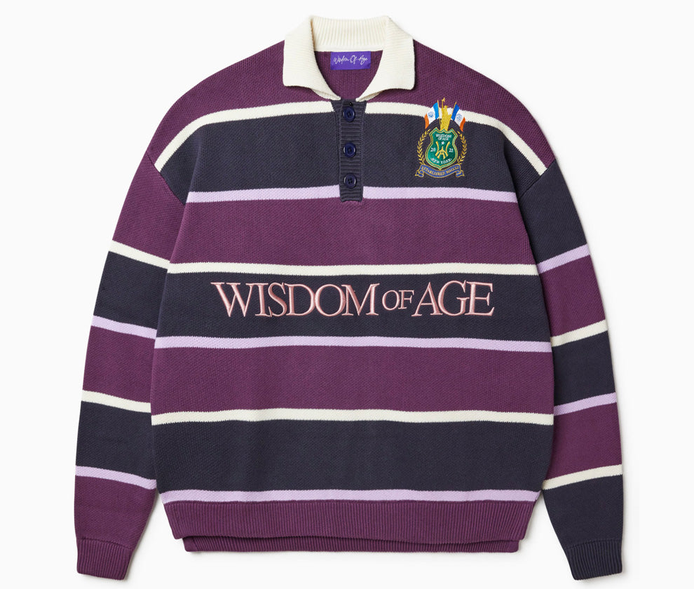 Front View of the Wisdom of age Berry rugby with alternating purple and white stripes, a Wisdom of age NY state patch on the left shoulder and Wisdom of age spelled out on the lower center.
