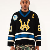 Male Model wearing WOA Hockey Jersey - Static Shock with a yellow WA logo and camouflage pants on a white background