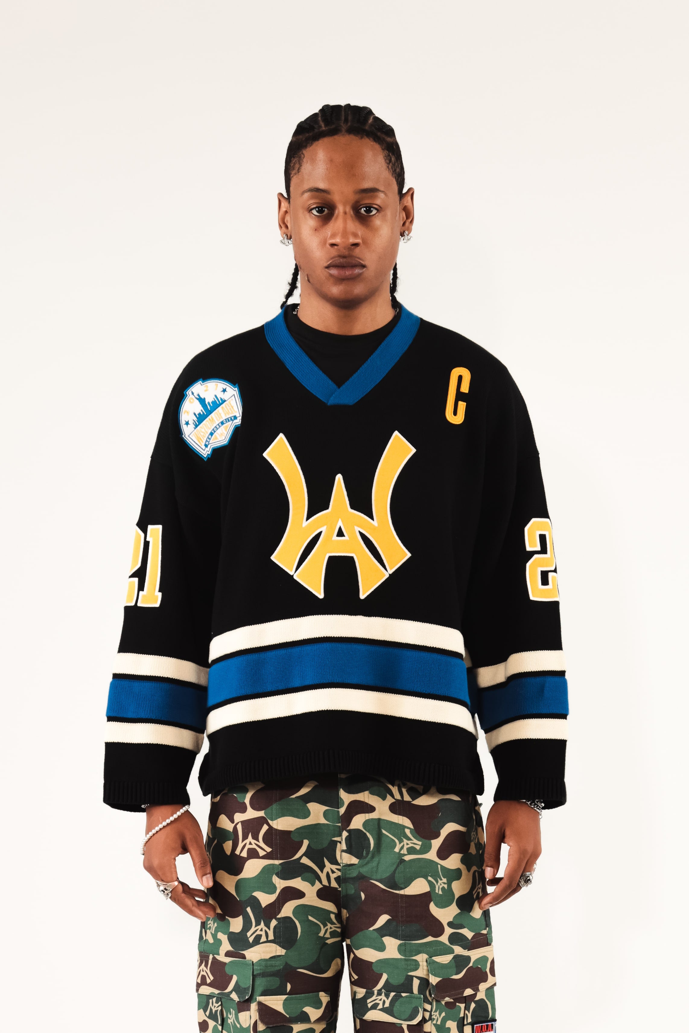 Male Model wearing WOA Hockey Jersey - Static Shock with a yellow WA logo and camouflage pants on a white background