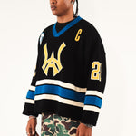 Male Model wearing WOA Hockey Jersey - Static Shock with a yellow WA logo and camouflage pants on a white background