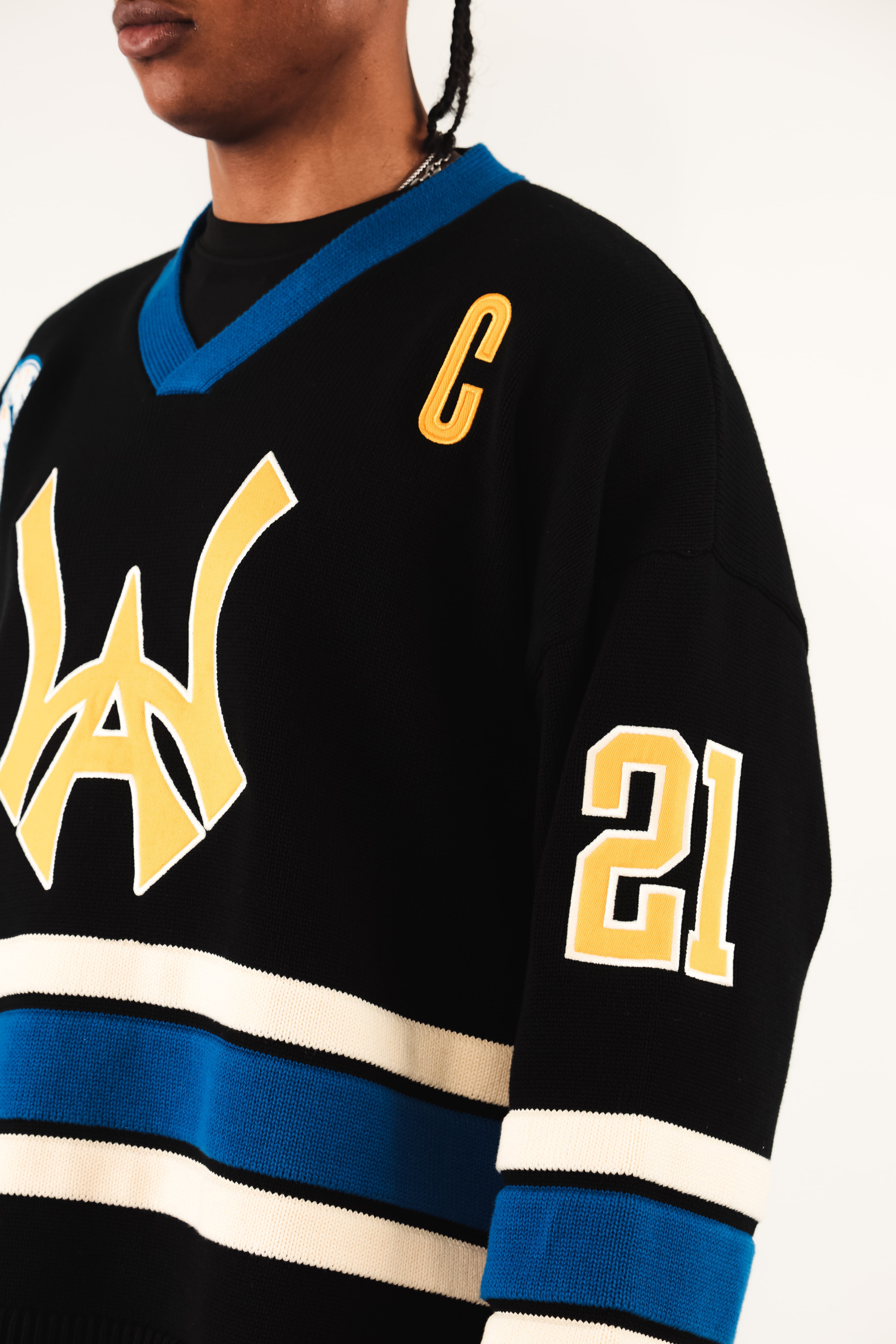 Close up WIsdom Of Age Hockey Jersey - Static Shock with yellow and blue details worn by a male model.