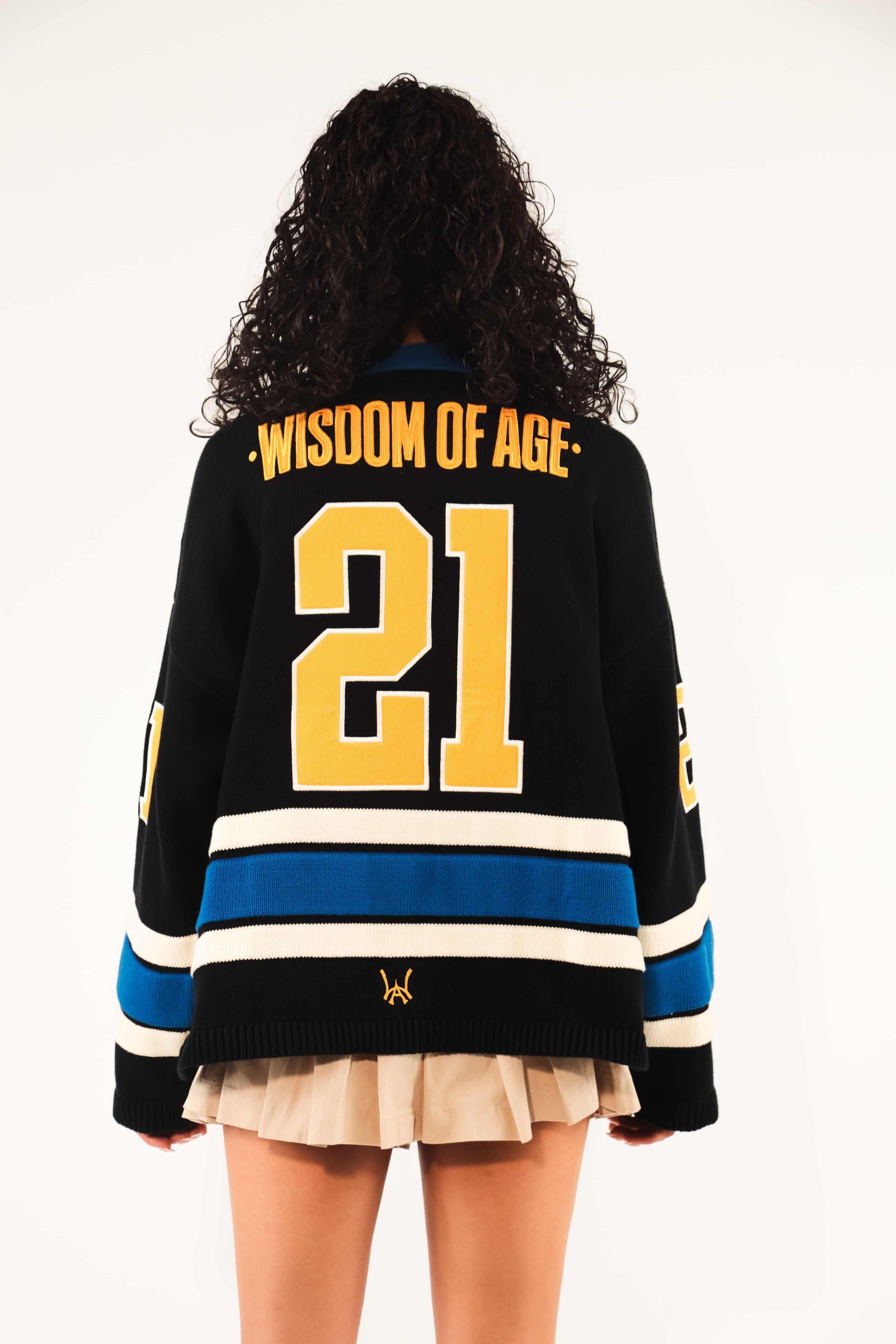 Rear View Of A Female model Wearing The Wisdom Of Age Hockey Jersey - Static Shock. 'Wisdom Of Age' written on the name plate with the number 21.