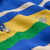 Close-up of a colorful striped sweater with the WA logo on a blue background