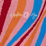 'Wisdom Of Age' embroidered on a fabric with multicolored stripes.