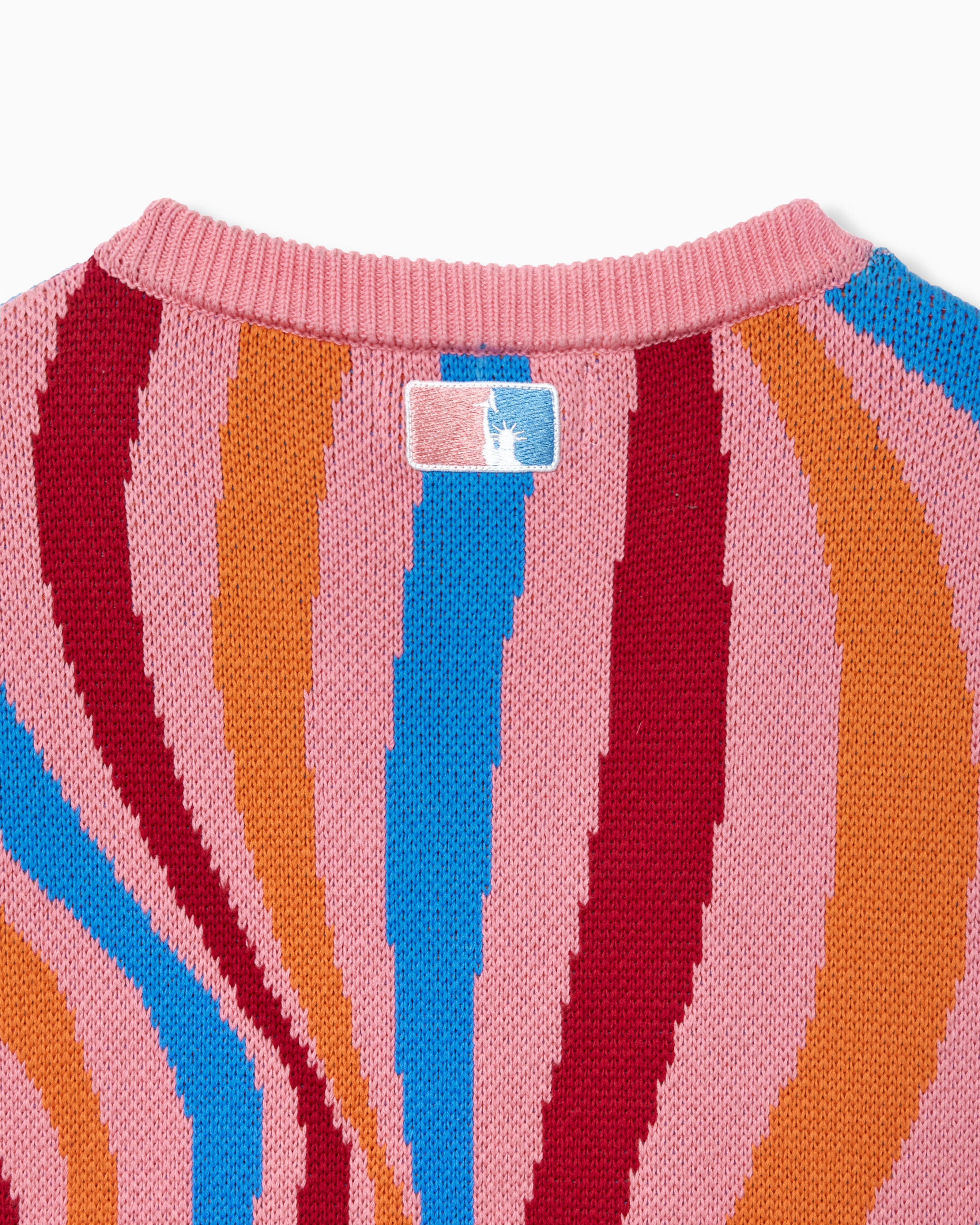 Close-up of a colorful striped sweater with a the NY Tough logo on a white background