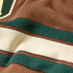 Close-up of a brown sweater with green and white stripes