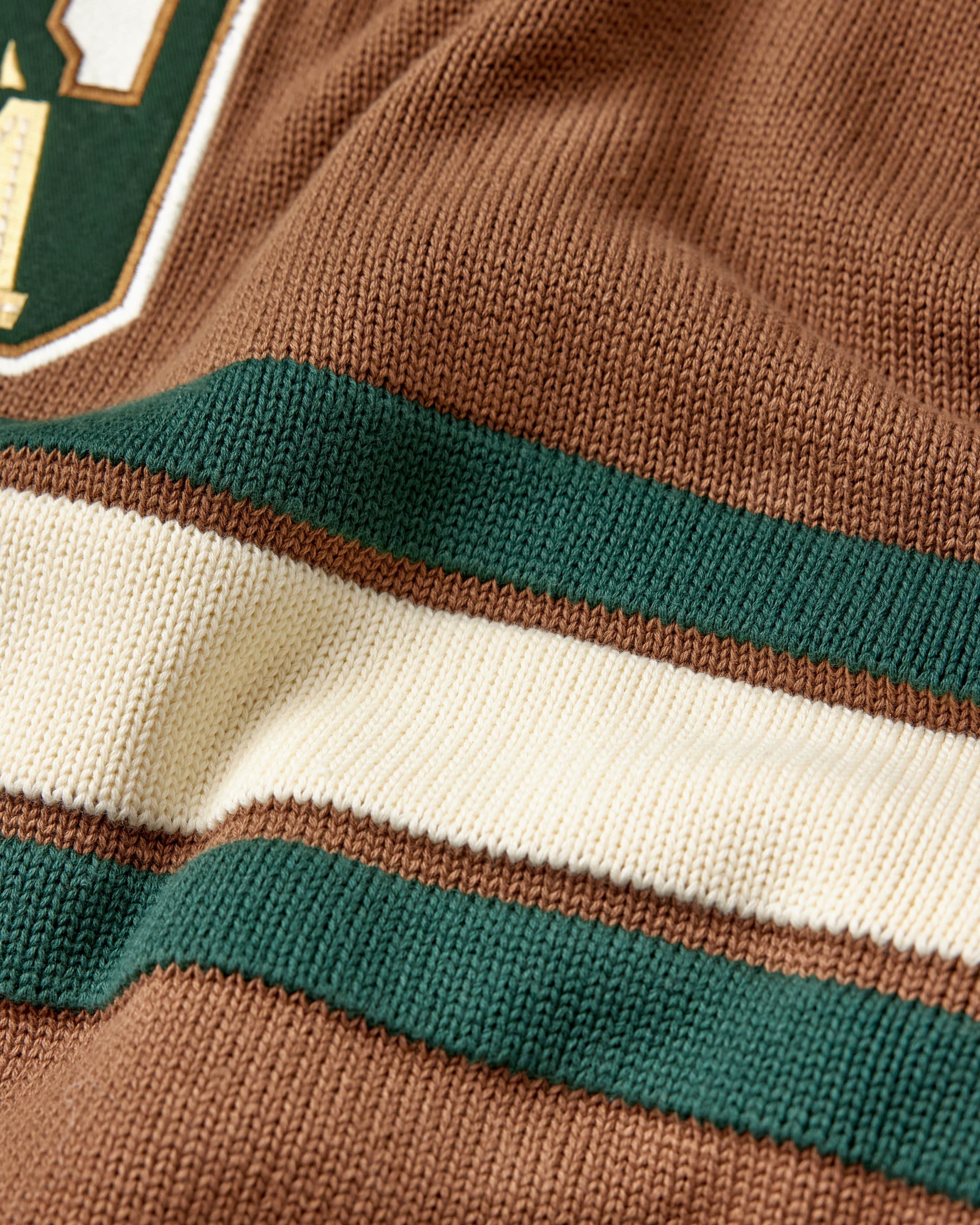 Close-up of a brown sweater with green and white stripes