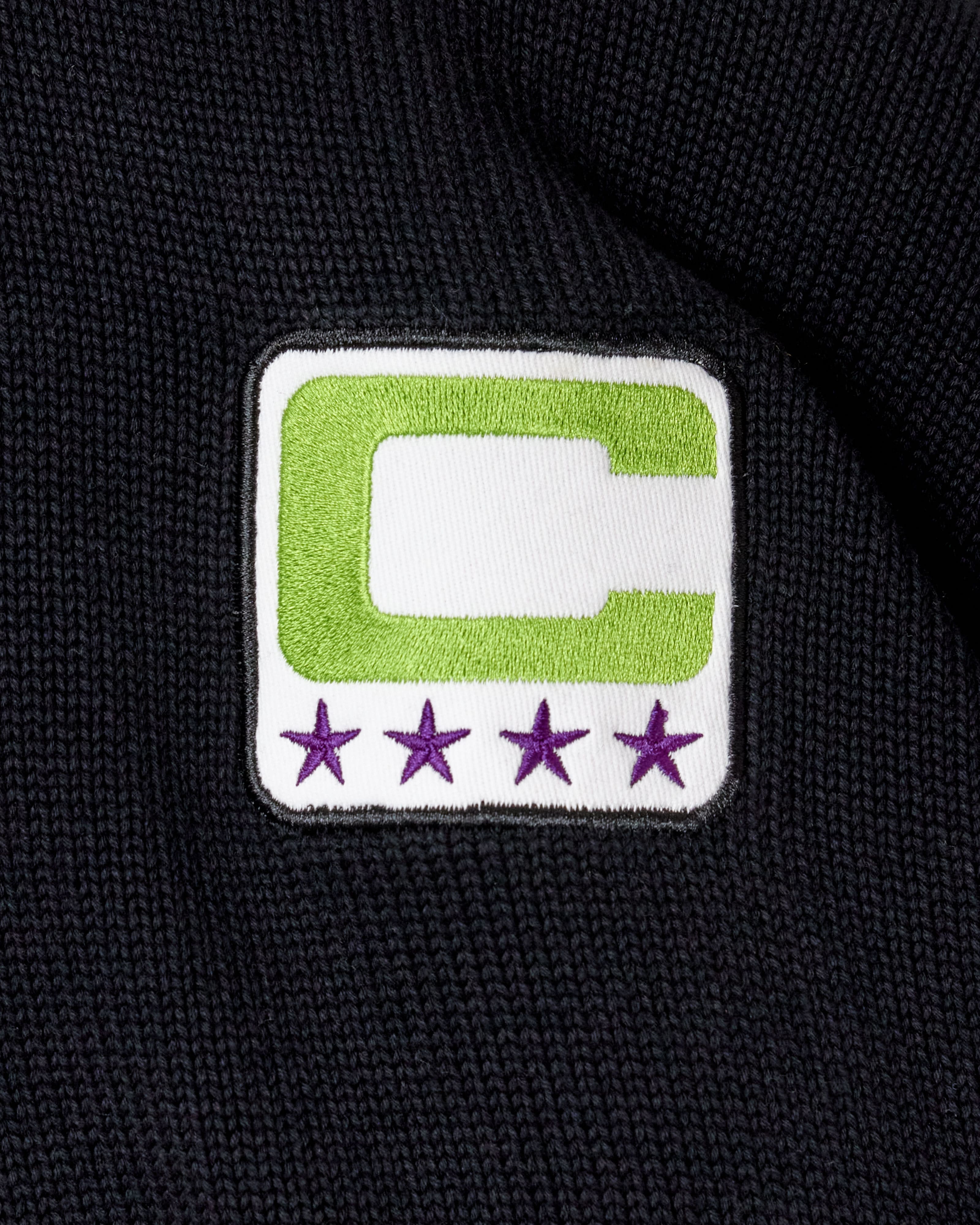 Captains patch with a neon green C and a white center on a black background