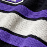 Close-up of a sweater with purple, white, and black stripes