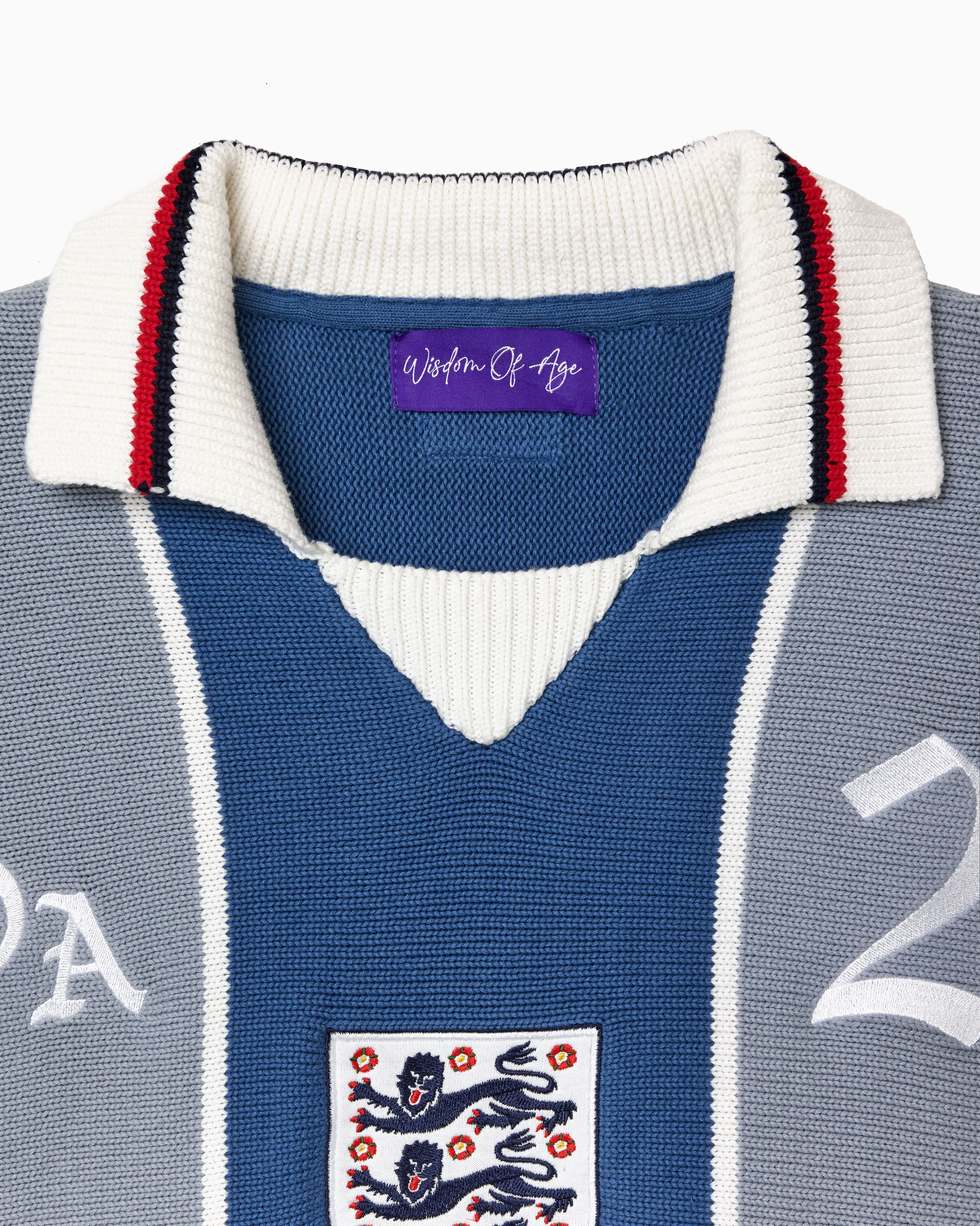 Blue and gray knitted soccer jersey with a WOA logo and number 21 on a white background