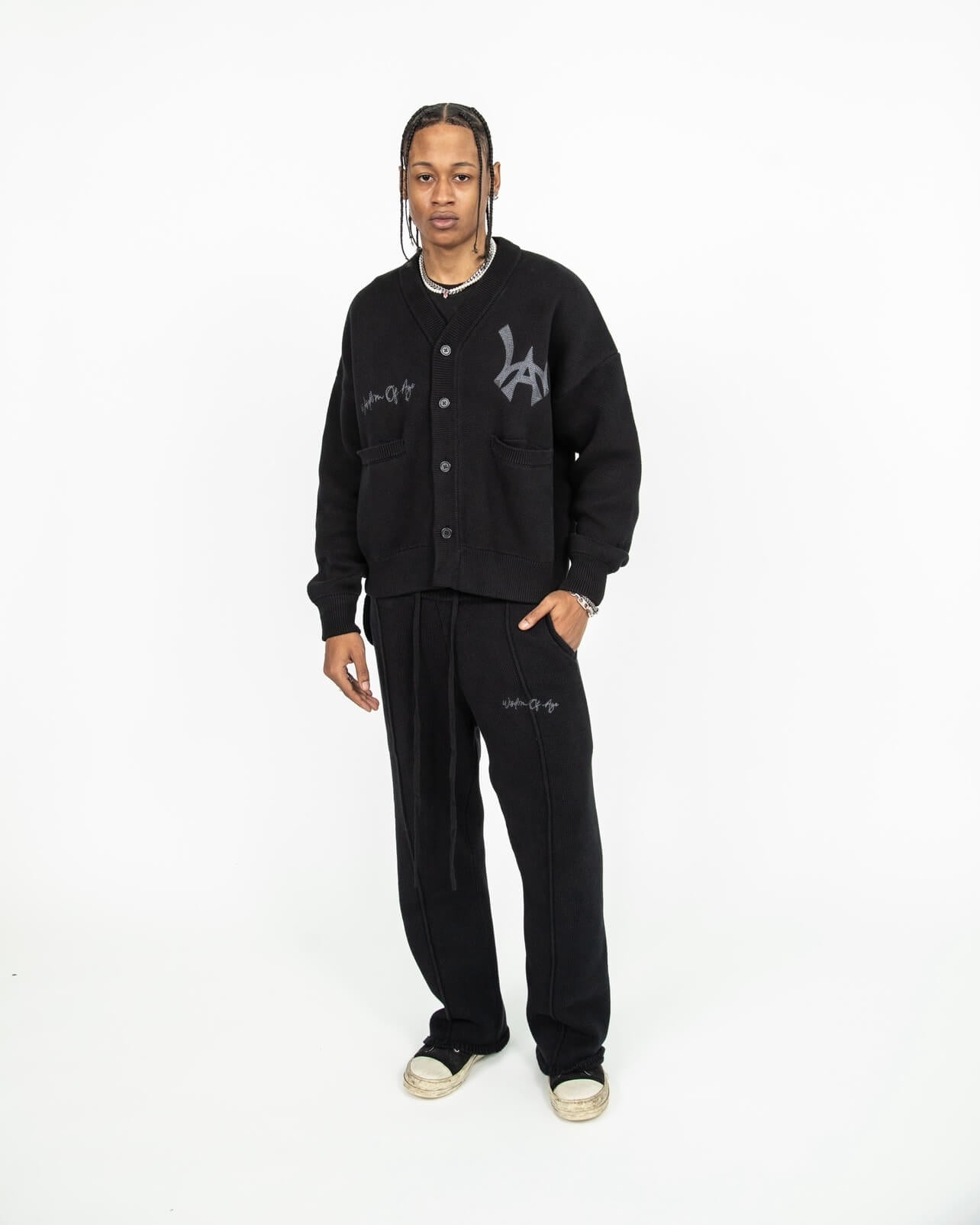 Front Profile of a model wearing the Black Cat City Cardigan paired with the Knit Sweatpants in Black