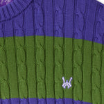 Close-up of a purple and green cable knit T-Shirt with WA logo on a white background.