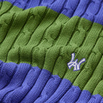 Close-up of a green and blue cable knit sweater with the WA logo