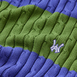 Close-up of a green and blue cable knit sweater with the WA logo