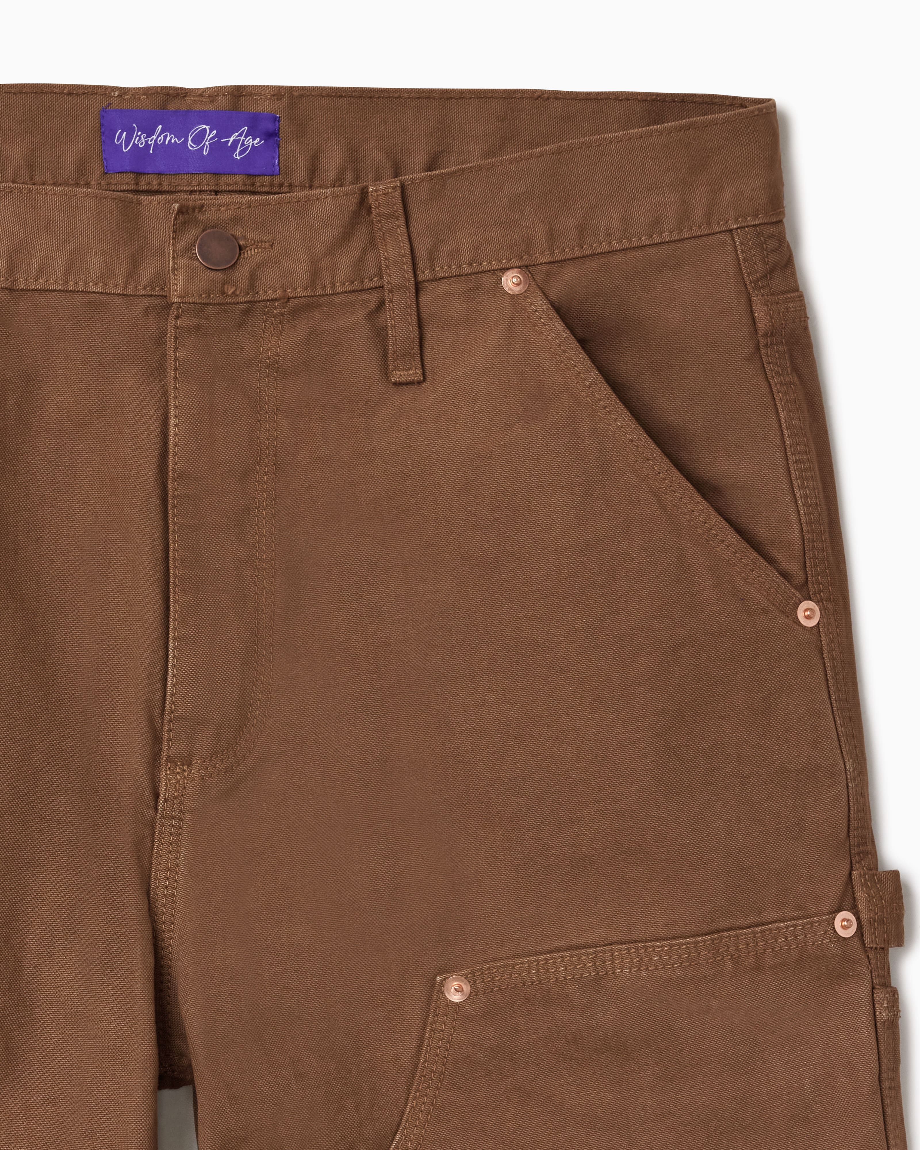 Close Up Of WOA Canvas Carpenter Shorts in Brick with WOA brand label on a white background