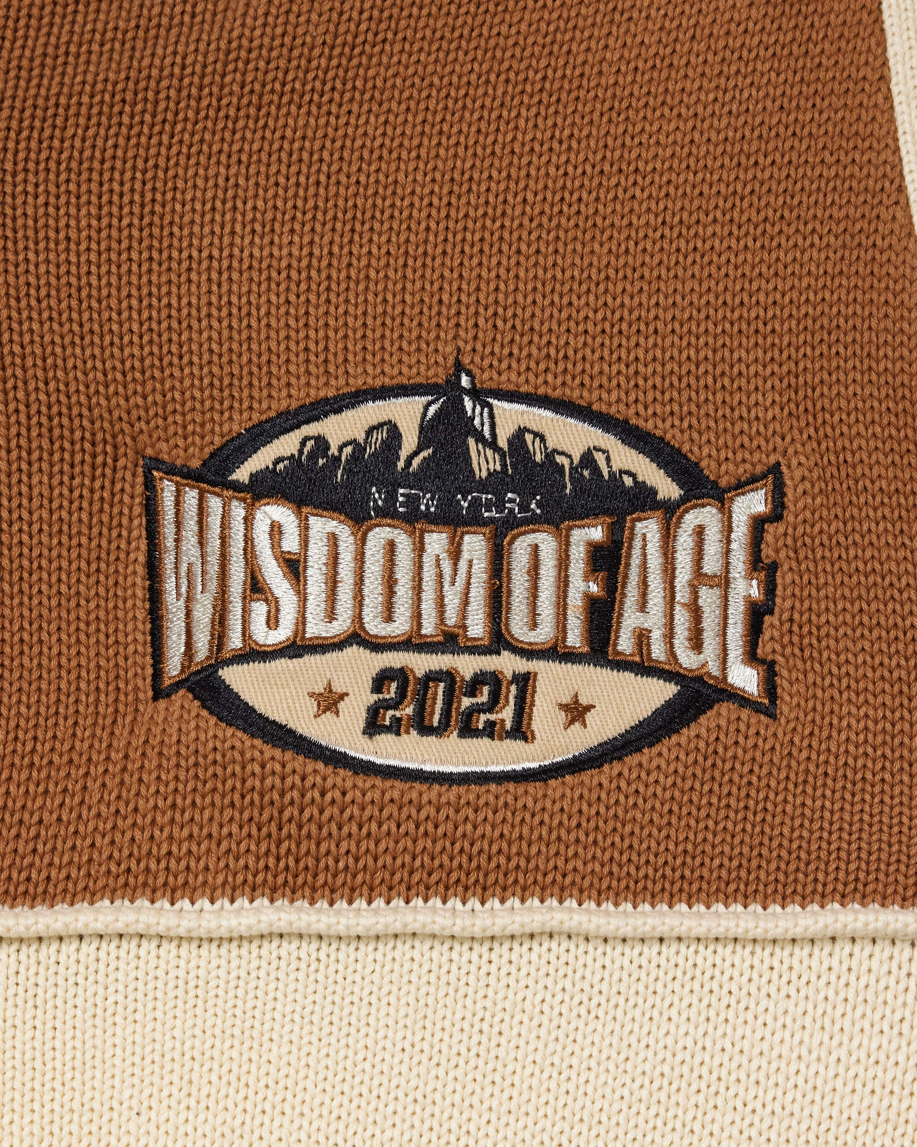 Embroidered Skyline patch on a brown and beige fabric with 'Wisdom of Age 2021' text.