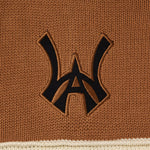 Close-up of a brown fabric with a black WA logo on a beige border
