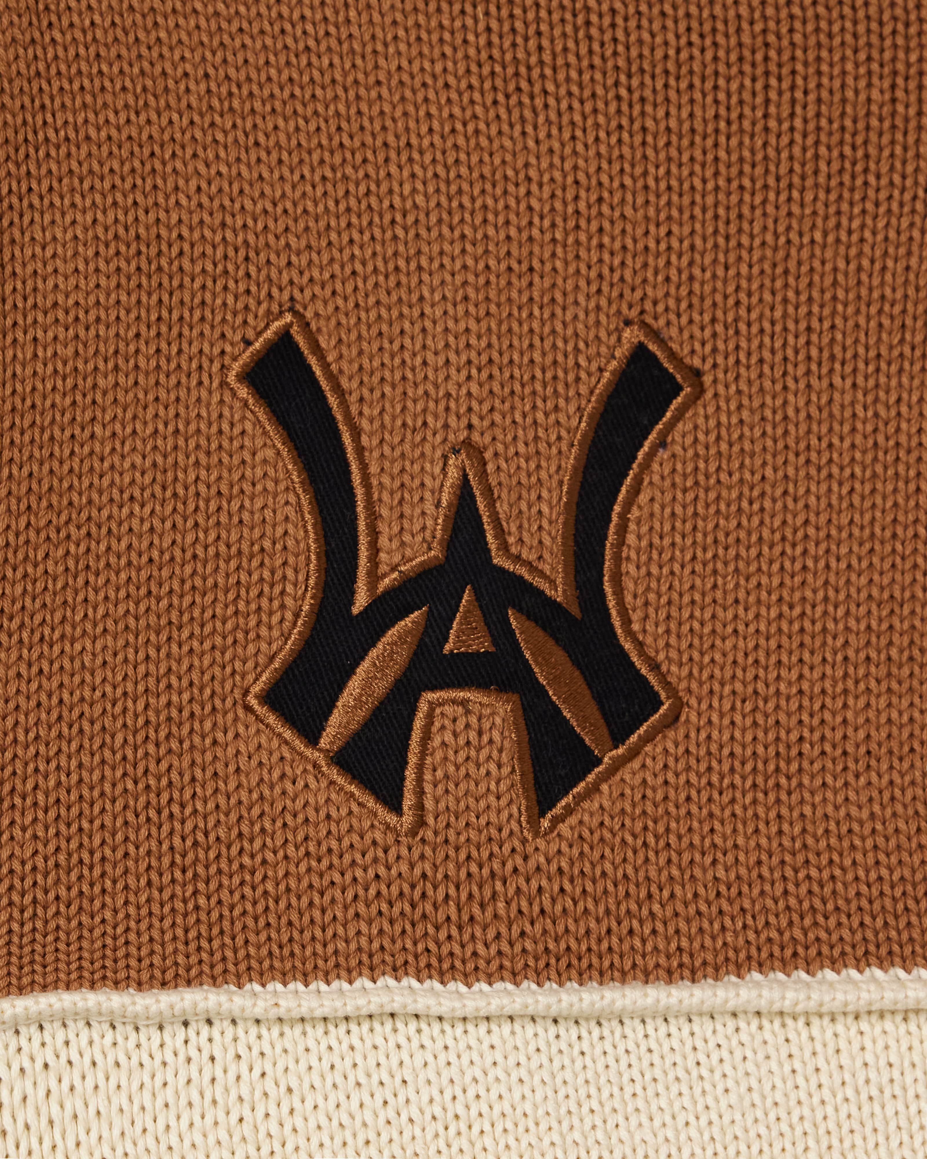 Close-up of a brown fabric with a black WA logo on a beige border