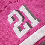 Close-up of the wisdom of age pink knitted football jersey with the number 21 on it.