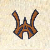 Embroidered WA logo on a cream fabric background