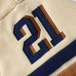 Close-up of the sleeve with blue and brown numbers '21' embroidered on it.