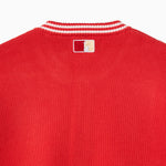 Closer look at the back of the cardigan with an embroidered square patch below the nape of the neck and collar. The patch contains the upper half of the Statue of Liberty in a "NY Tough" inspired logo.