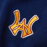 Close Up Of The Wisdom Of Age Knit Clinton Sweatpants Navy Front Logo Patch in Yellow.