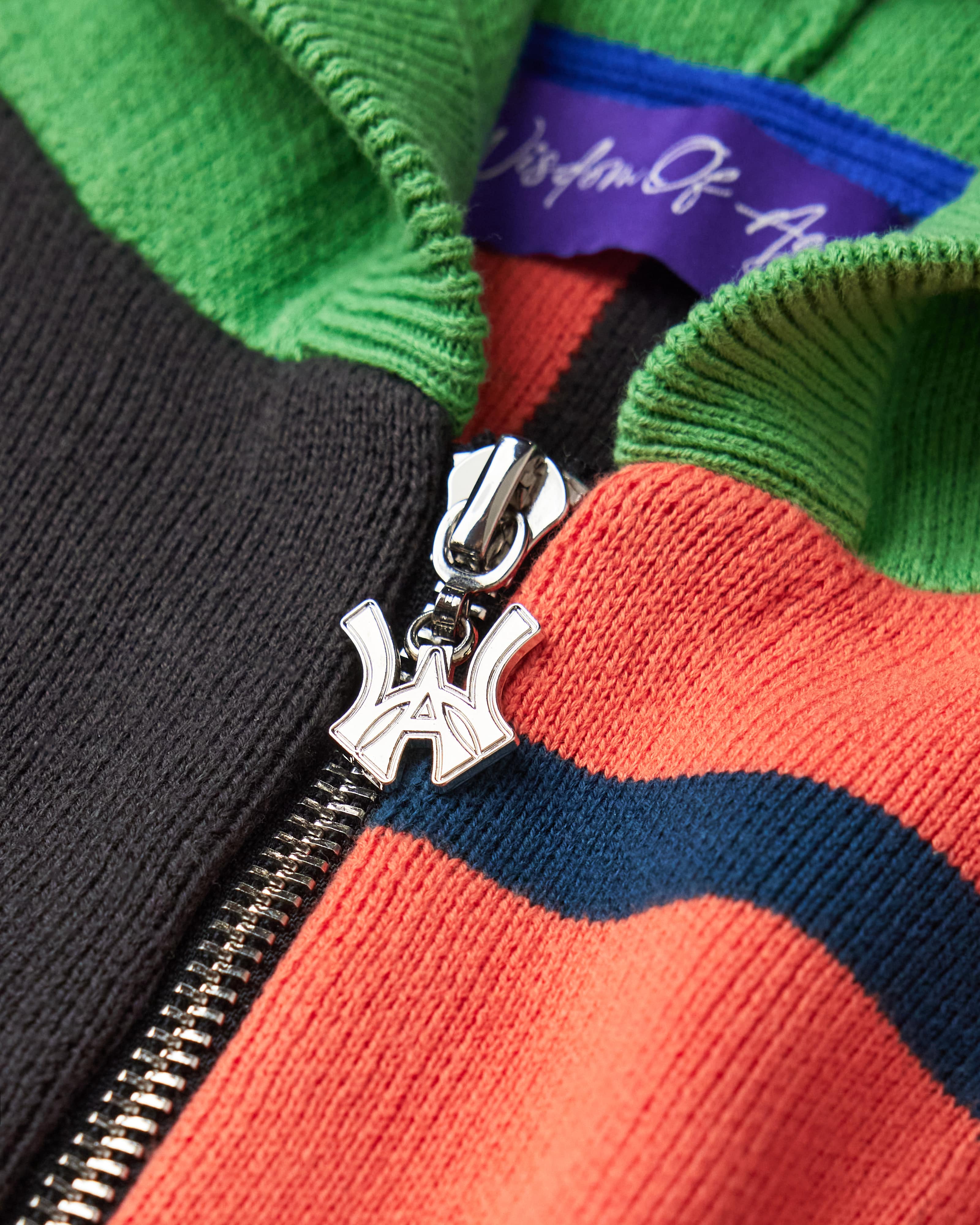 Close Up Of The Wisdom Of Age Knit Clinton Hoodie Multi-Color Zipper Front View. WA logo on the zipper with a chrome finish.