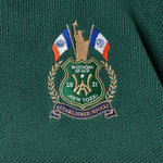 Embroidered WOA logo on a green and red garment with flags and text.