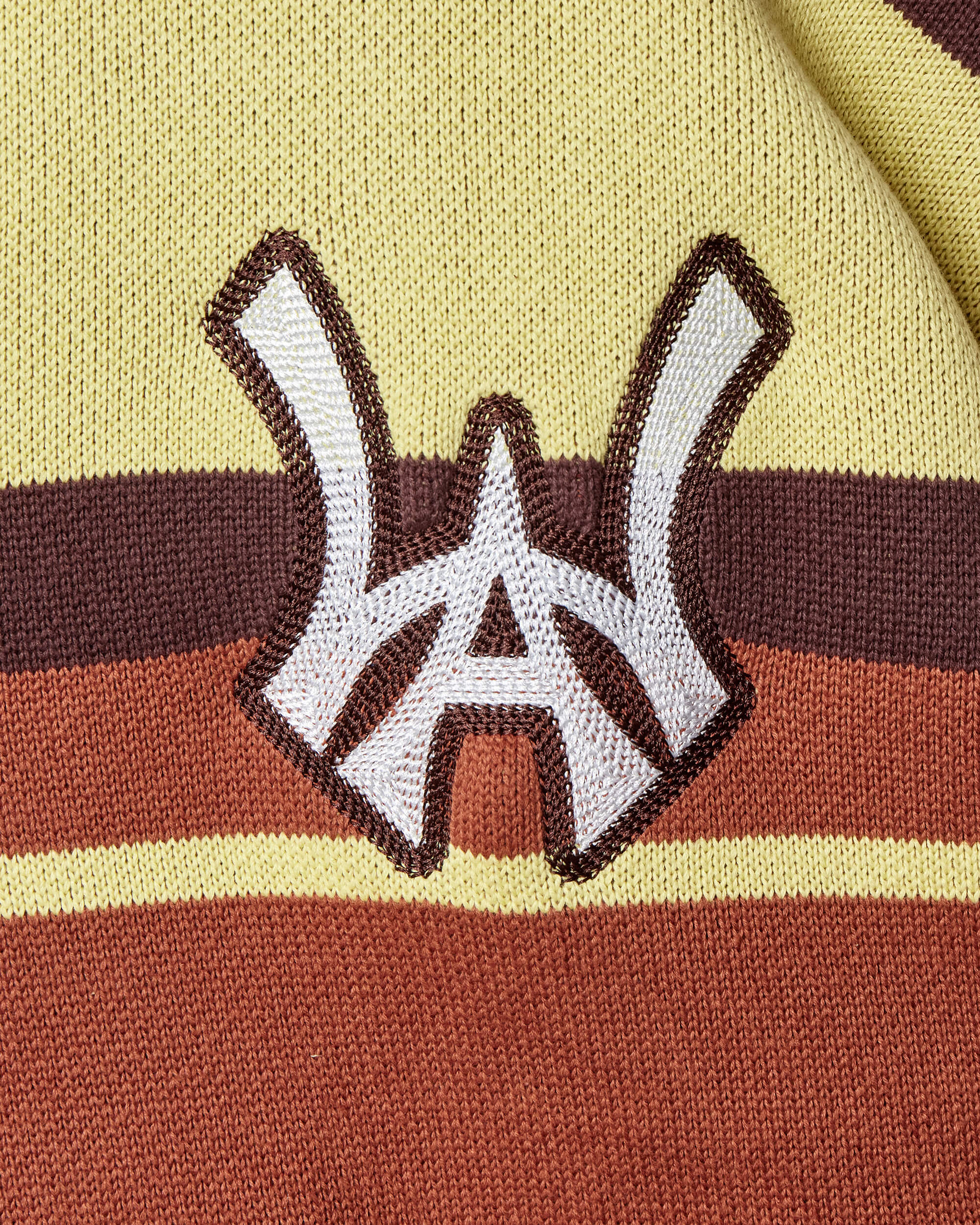 Closer look at the brand logo in a monogram font of connecting the "W" and "A" located on the upper left side of the sweater