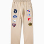 Wisdom Of Age Sandstone sweatpants with various Patches on a white background