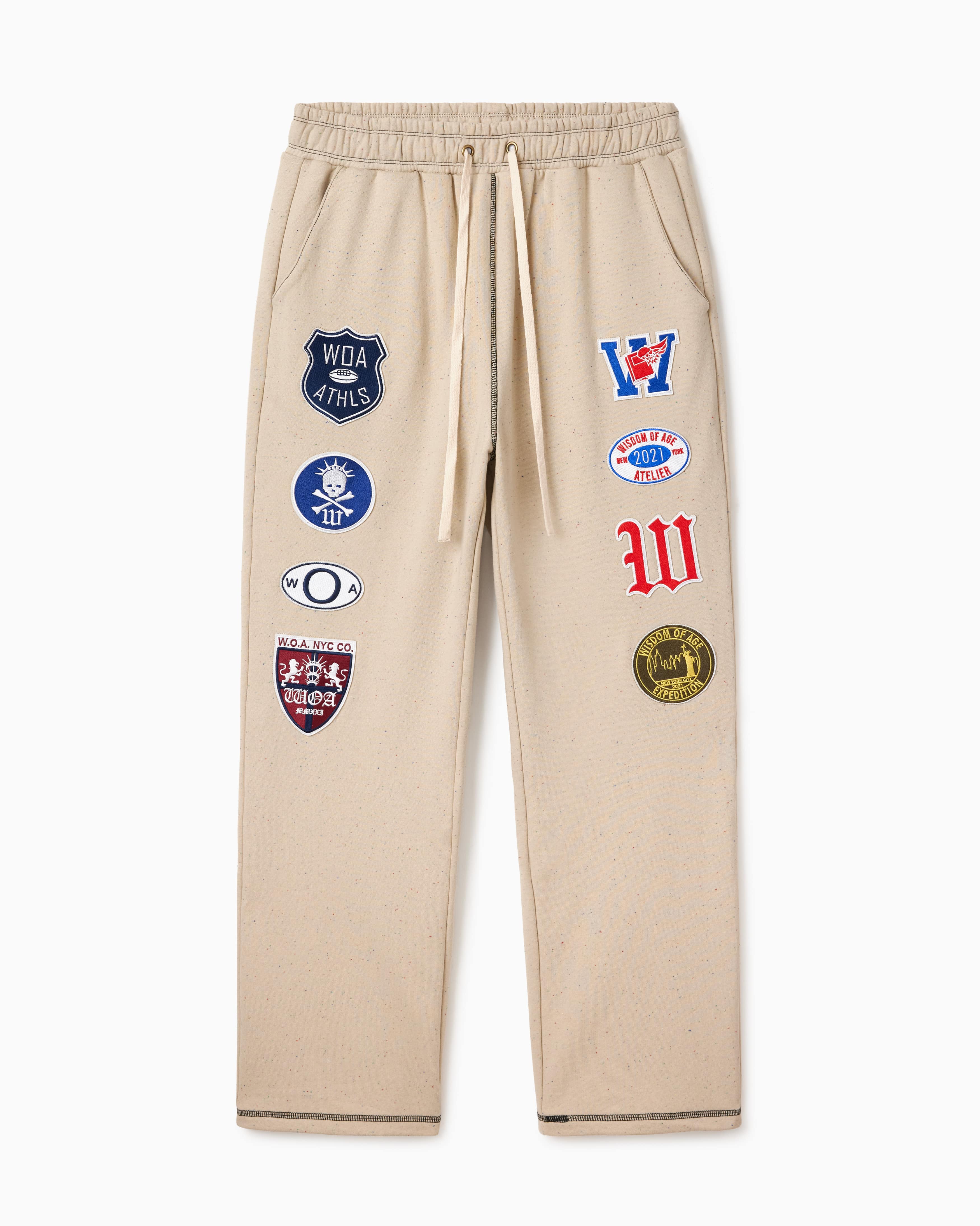 Wisdom Of Age Sandstone sweatpants with various Patches on a white background