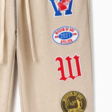 Wisdom Of Age Sandstone pants with patches on a white background