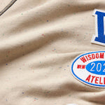 Close-up of the wisdom of age sand stone sweat pants fabric with patches.