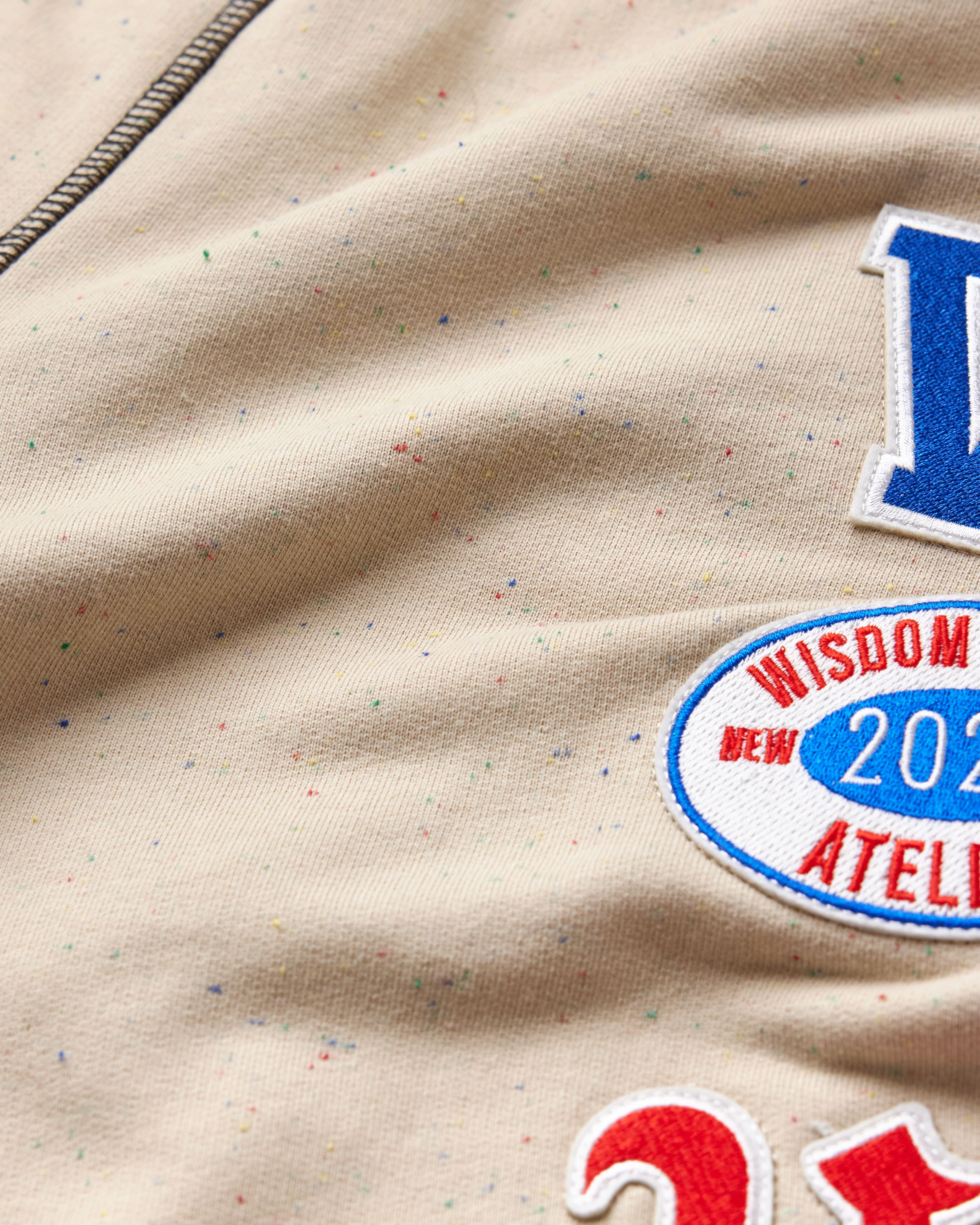 Close-up of the wisdom of age sand stone sweat pants fabric with patches.