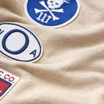 Close-up of a the wisdom of age sandstone sweat pants with patches 
