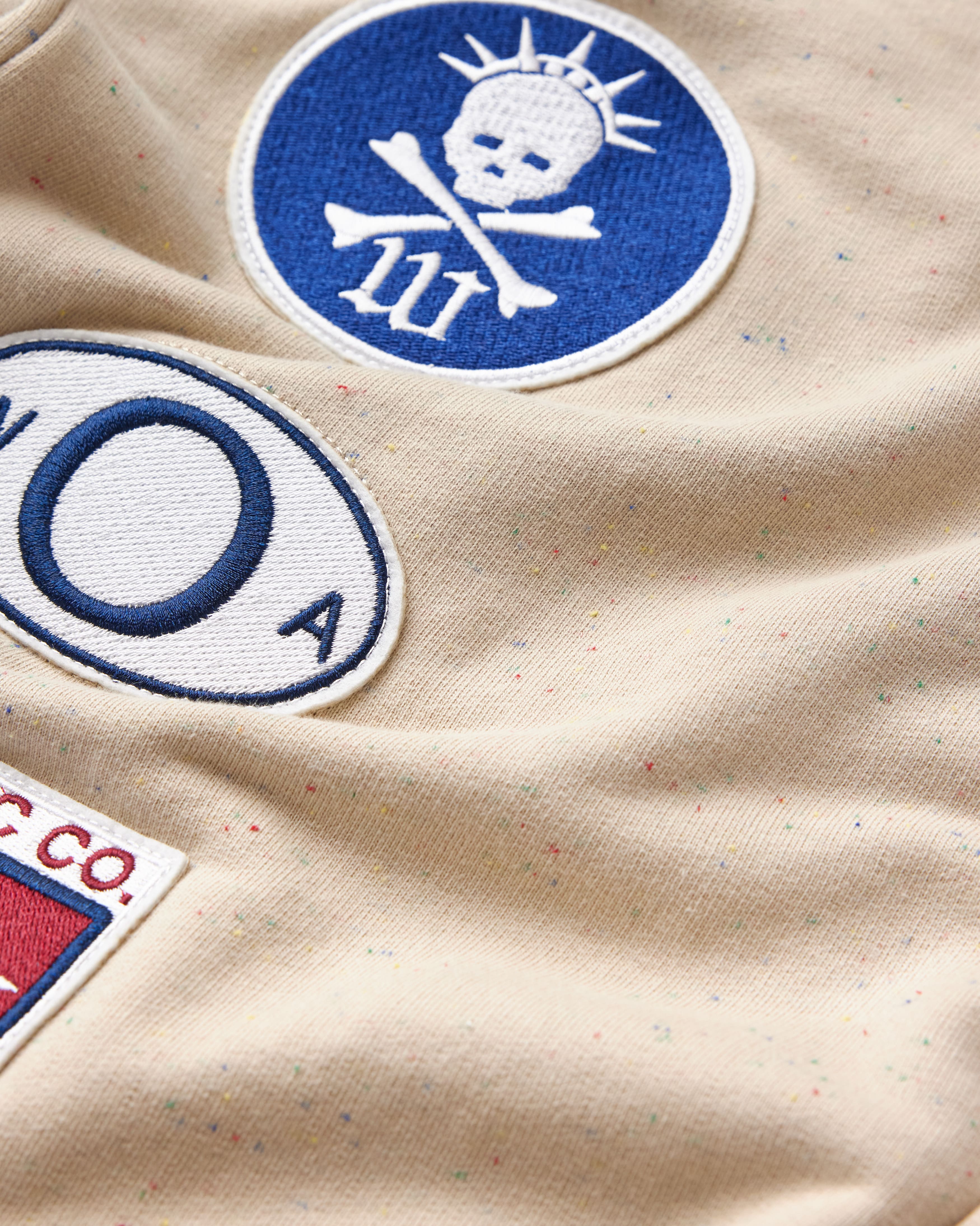 Close-up of a the wisdom of age sandstone sweat pants with patches 