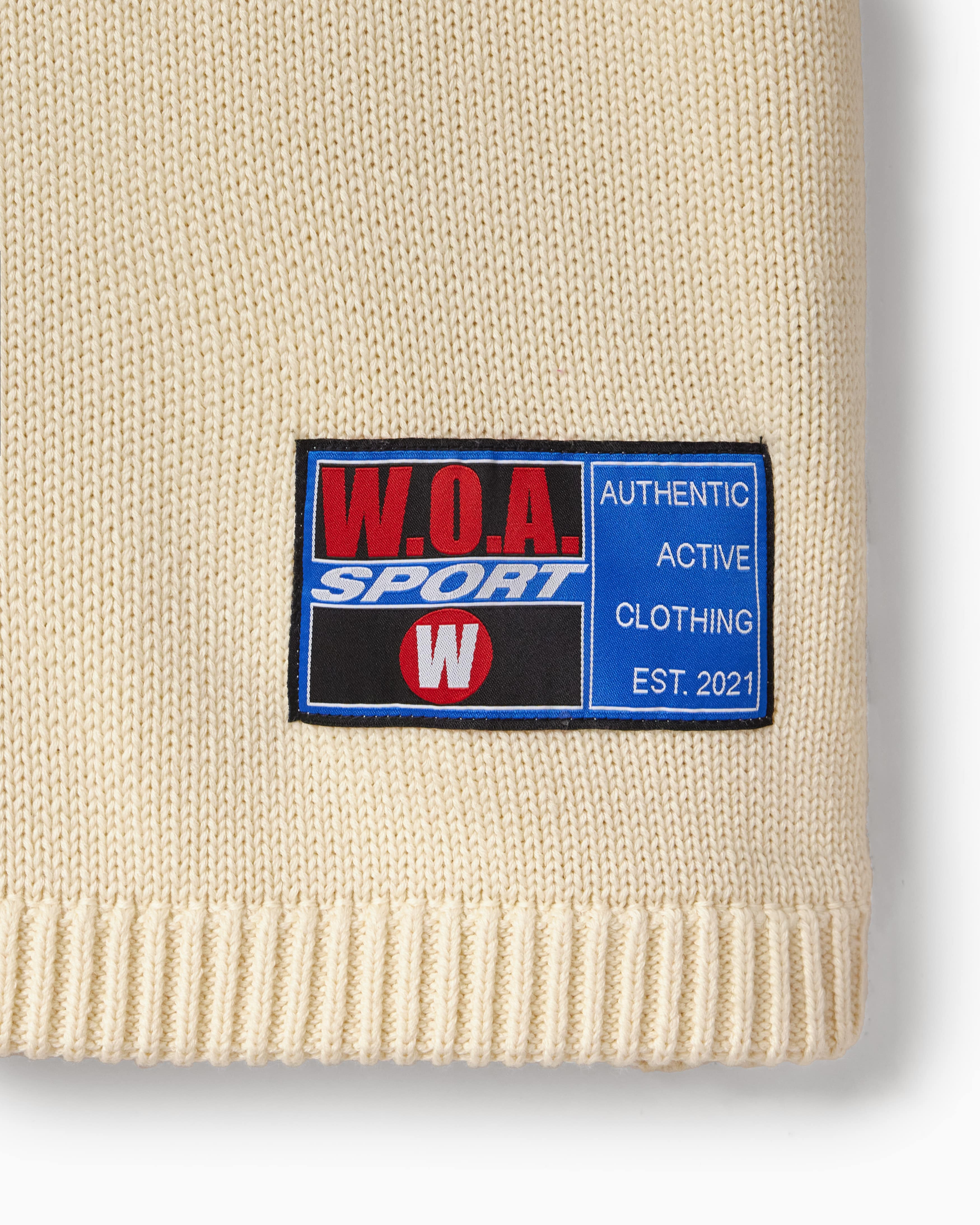 Beige knit baseball jersey tag with a W.O.A. Sport label