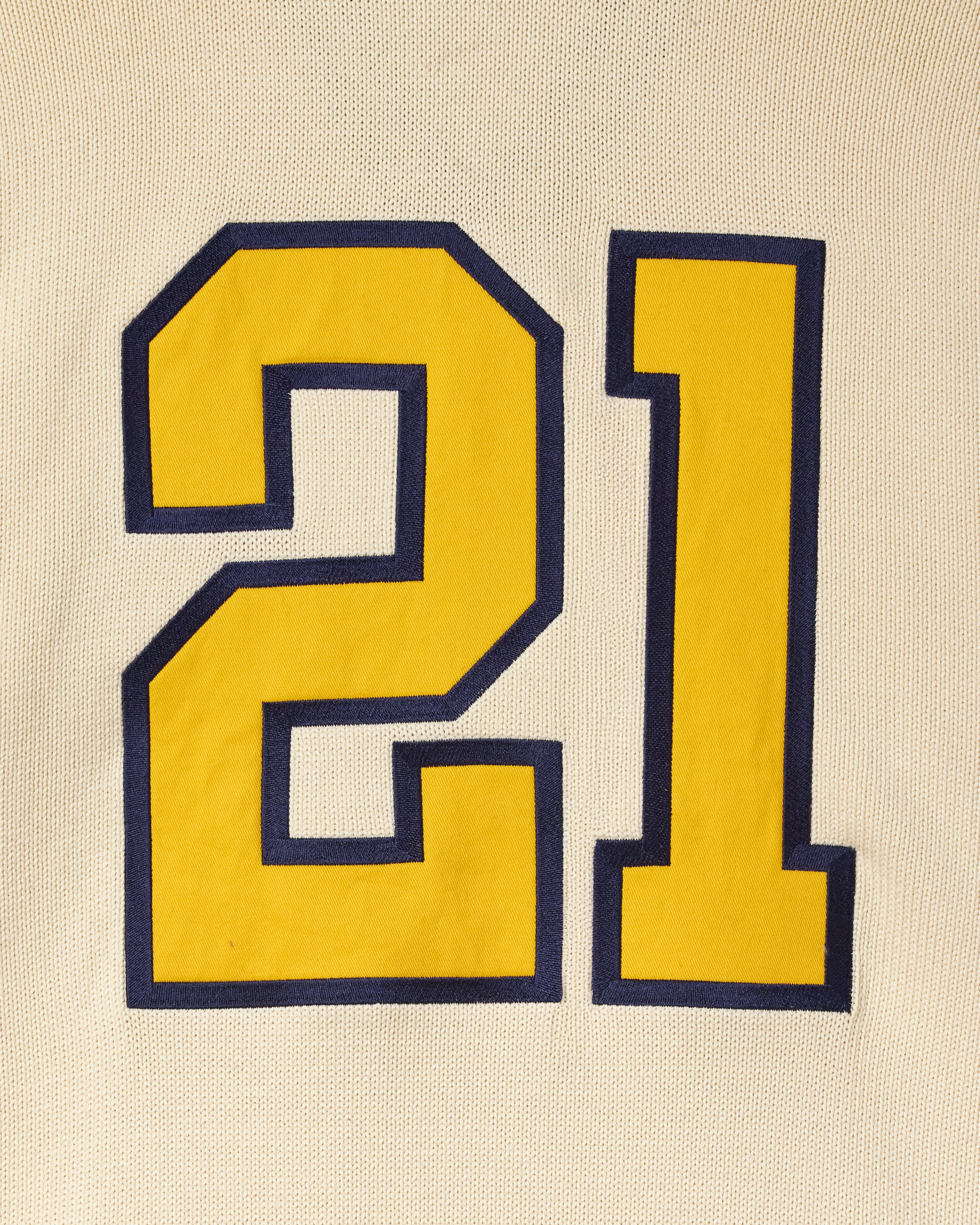 Yellow number '21' with blue border on cream background
