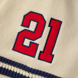 Red number 21 on a cream knitted baseball jersey with navy border