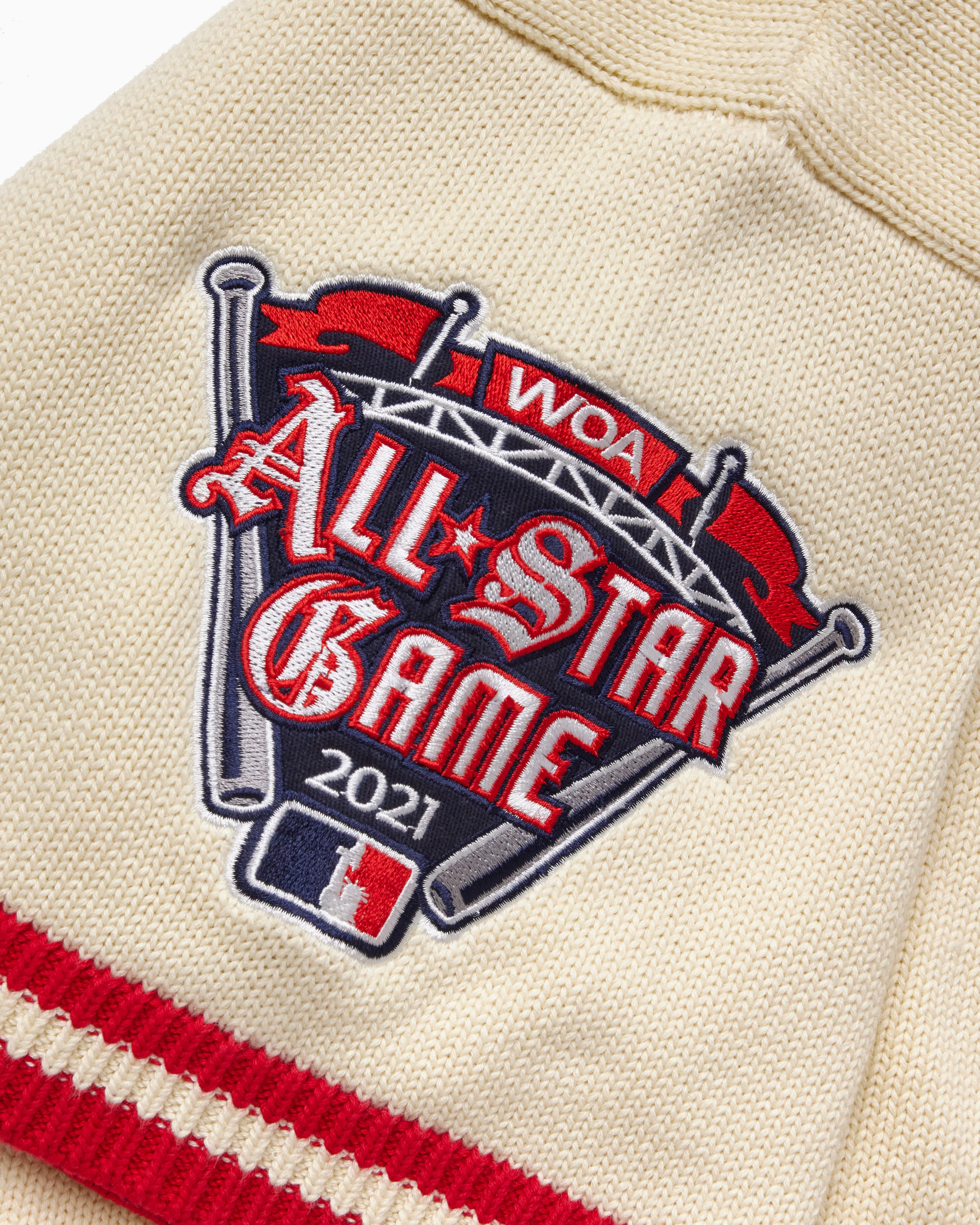 Patch on a cream knitted baseball jersey with 'WOA All-Star Game 2021' text