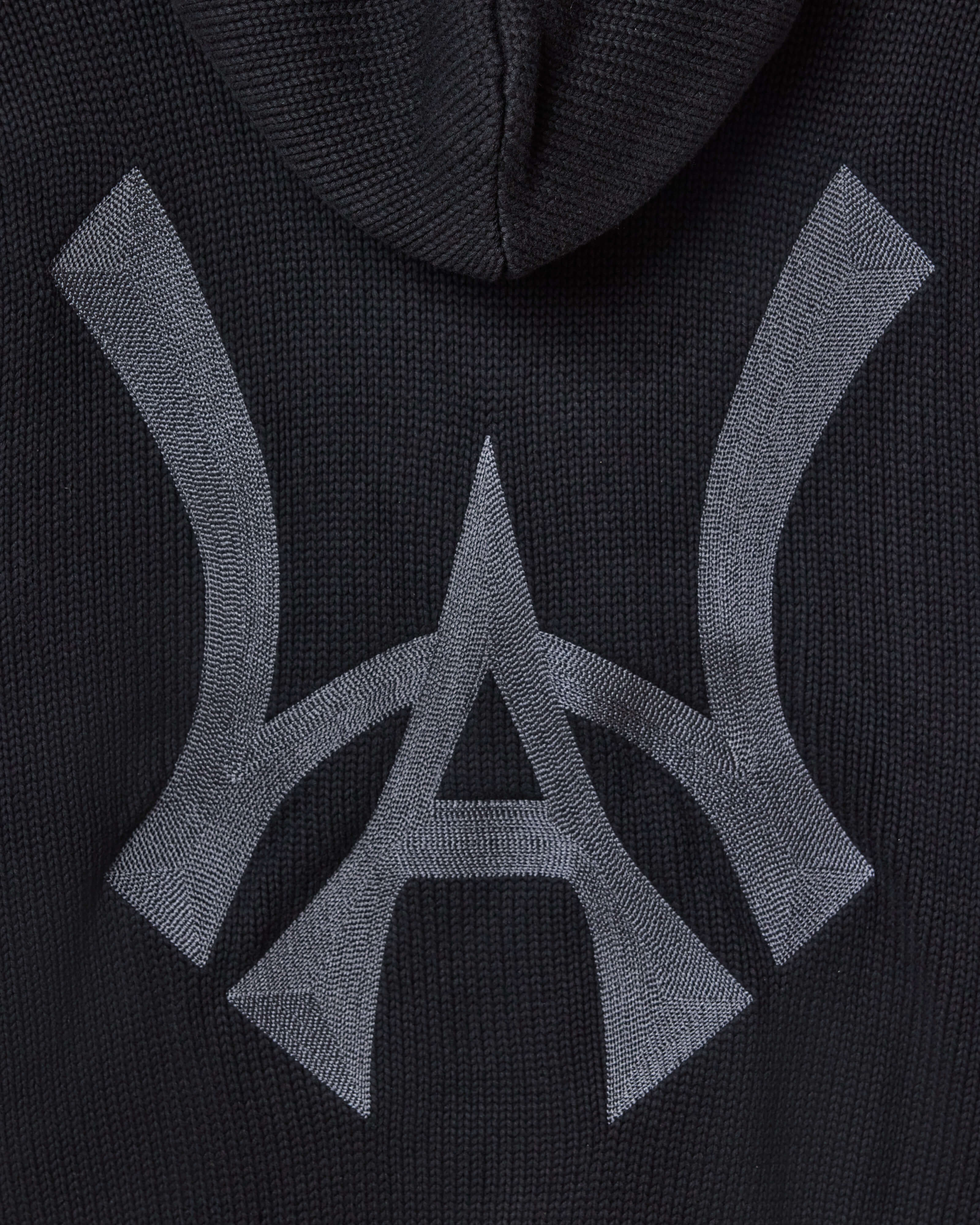 Closer look at the brand logo in a monogram font of connecting the "W" and "A" located on the middle back of the hoodie.