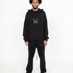 Front head to toe profile of the Knit Hoodie in black. The Hoodie is paired with the Knit Sweatpants in black.
